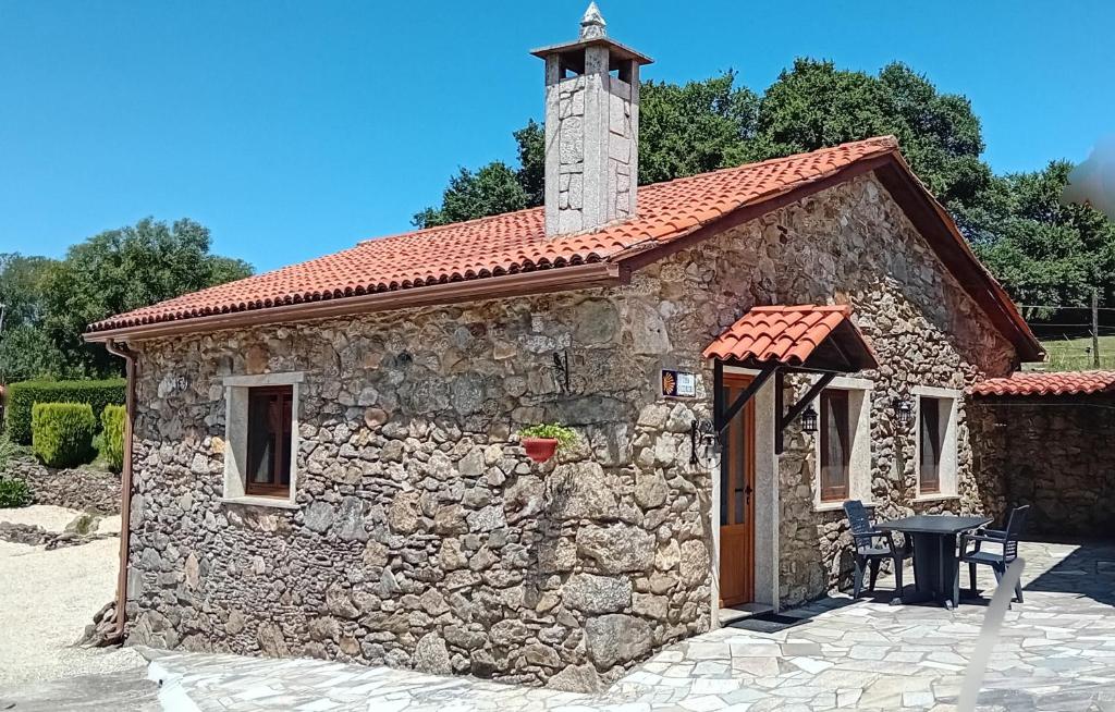 a small stone building with a clock tower on top at Stone Cottage O CEBREIRO in Curtis