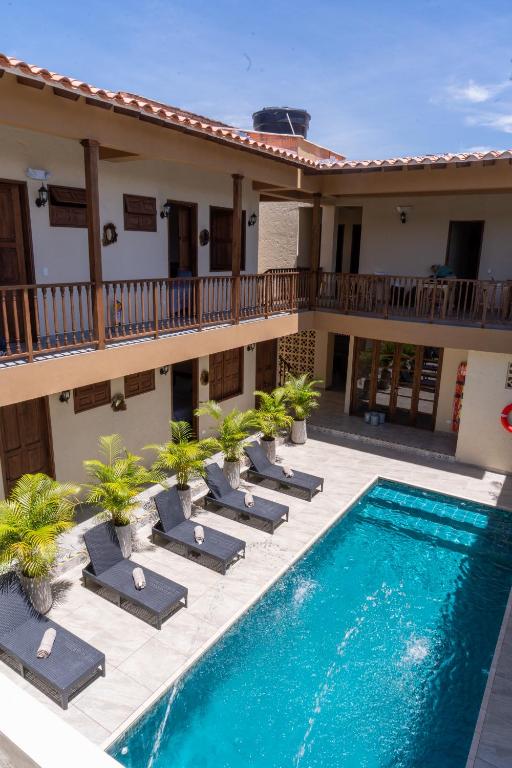 a hotel with a swimming pool and lounge chairs at Hotel Boutique Lomas Colonial in Santa Fe de Antioquia