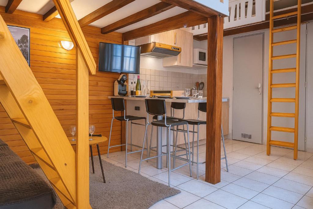 a kitchen with a counter and stools in a room at Le Nid Des Marmottes in Cauterets