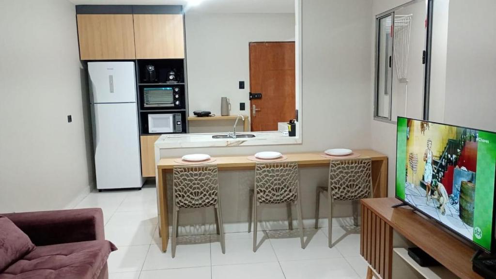 una cucina con tavolo e alcune sedie di lindo apartmento 8 km do Gru airport a Guarulhos
