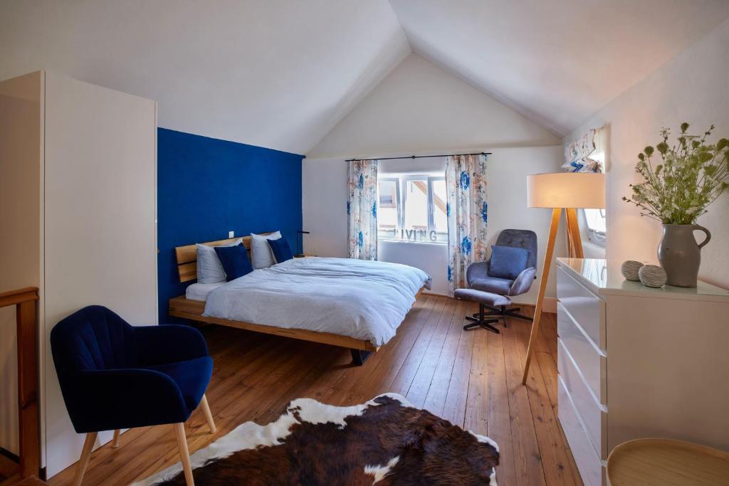 a bedroom with a bed and a blue accent wall at Molls Ferienhäusel in Sankt Martin