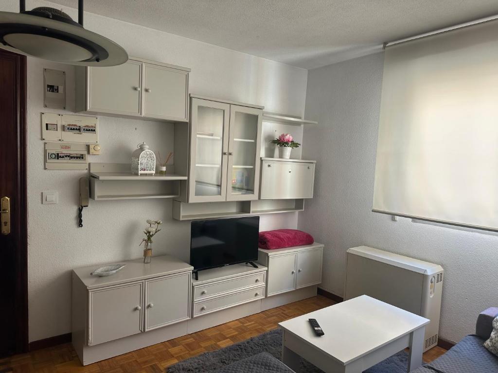 a living room with white cabinets and a flat screen tv at centro de Medina de Pomar in Medina de Pomar