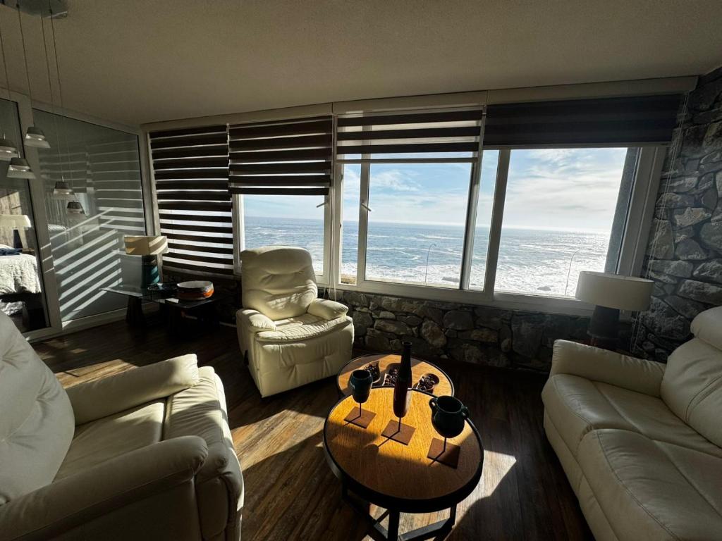a living room with a couch and a table at Reñaca Cochoa departamento frente al mar in Vina del Mar