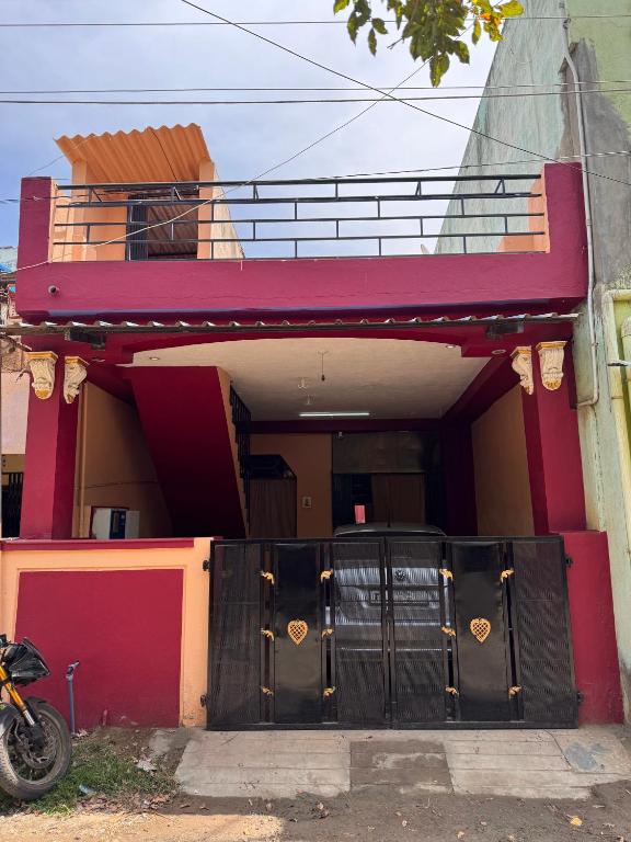 a house with a garage with a bike parked in front at Jose Homestay in Madurai