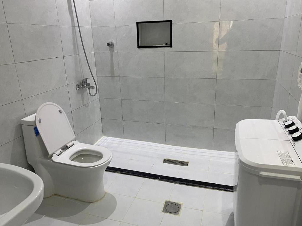 a bathroom with a shower with a toilet and a sink at شقق الضباب 1 in Al Baha