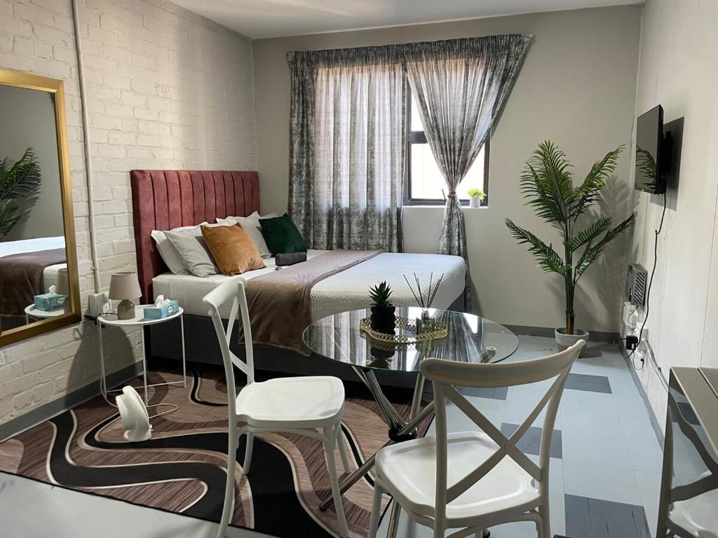 约翰内斯堡StayEasy in Maboneng的一间卧室，里面有一张床、一张桌子和几把椅子。