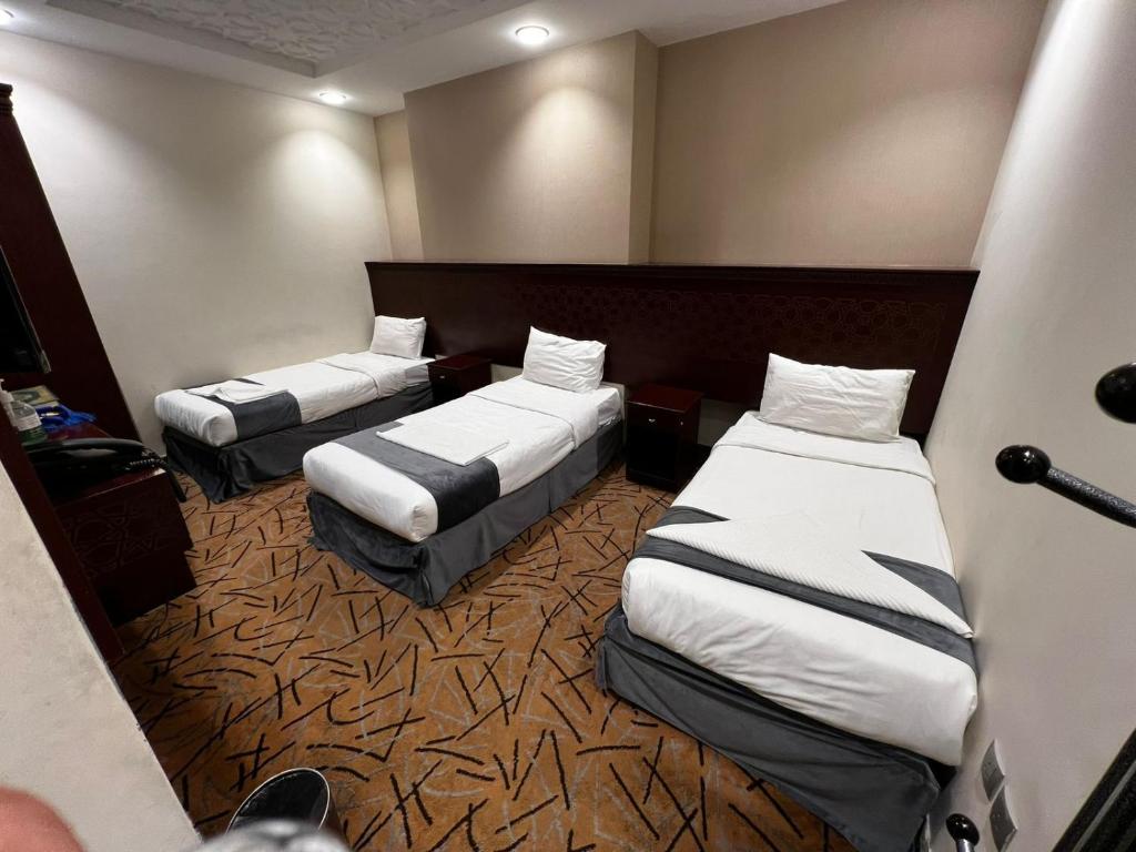 a room with two beds in a hotel room at فندق صفوة الخير المحبس الفندقية in Al Khansāk