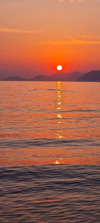 a sunset over a body of water with the sun setting at La Casetta in Marina di Massa