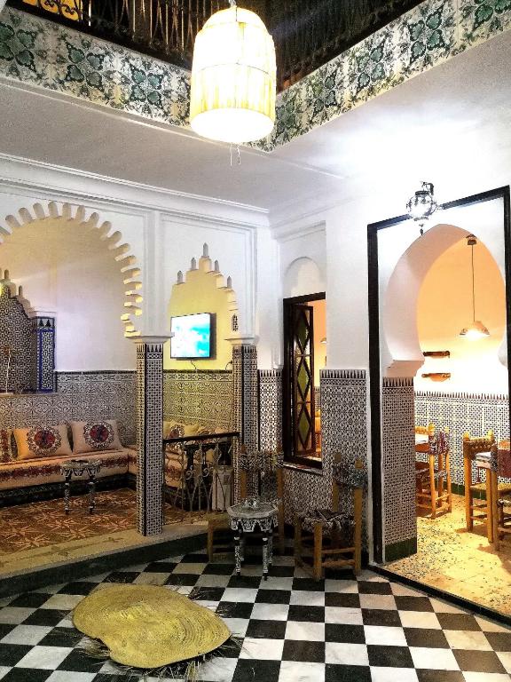 a room with a checkered floor and a tv at Riad la madriguera de Tetuan in Tétouan