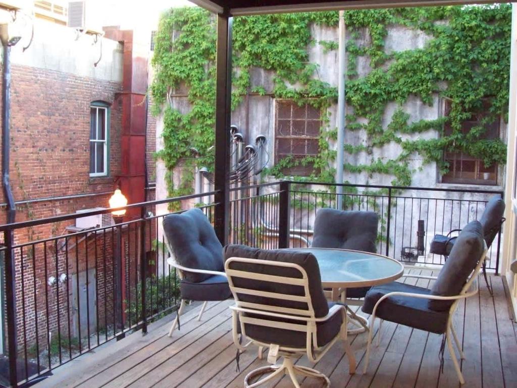 a patio with a table and chairs on a balcony at Large Historic Downtown Loft - Rear in Macon