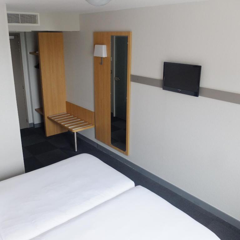 a room with a bed and a mirror at B&B HOTEL La Rochelle Centre in La Rochelle