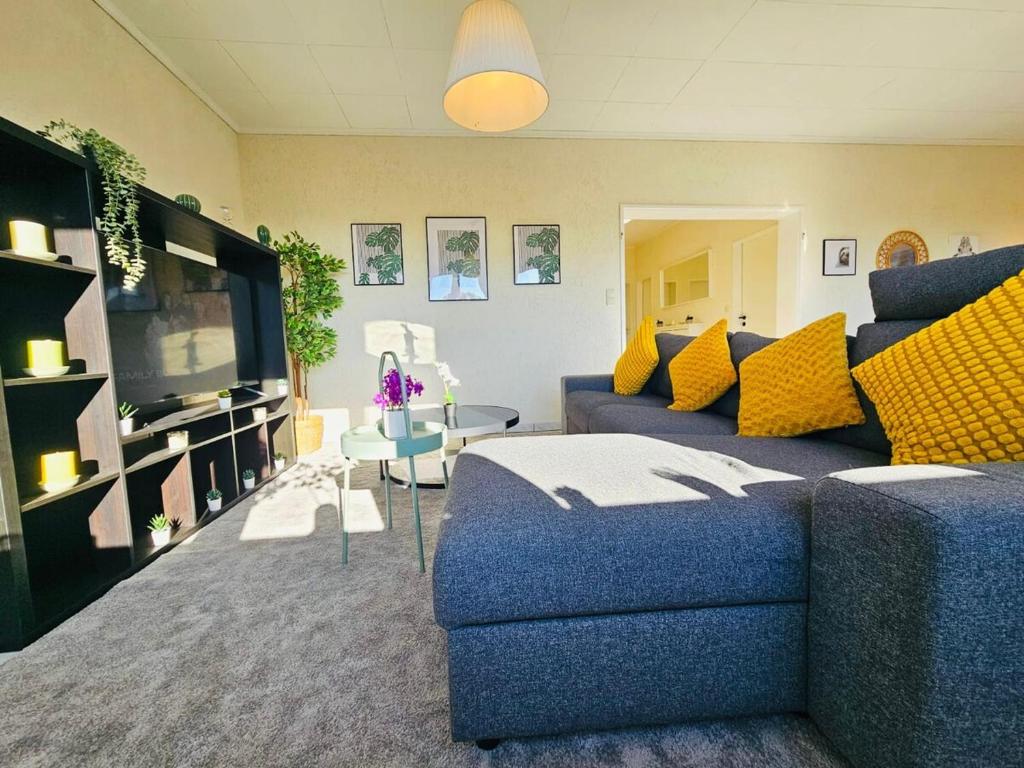 a living room with a blue couch and yellow pillows at Chic Urban Stay 2BR with parking- BEL4 in Luxembourg