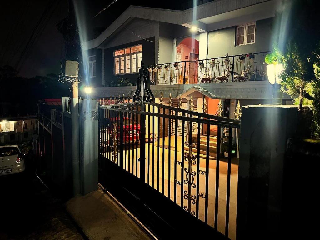 a wrought iron fence in front of a house at night at Roy-al Homestay 1 in Shillong