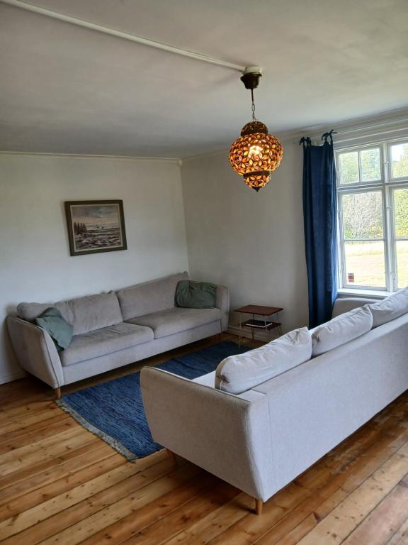 a living room with two couches and a chandelier at Traditional Swedish loghouse in Hagfors