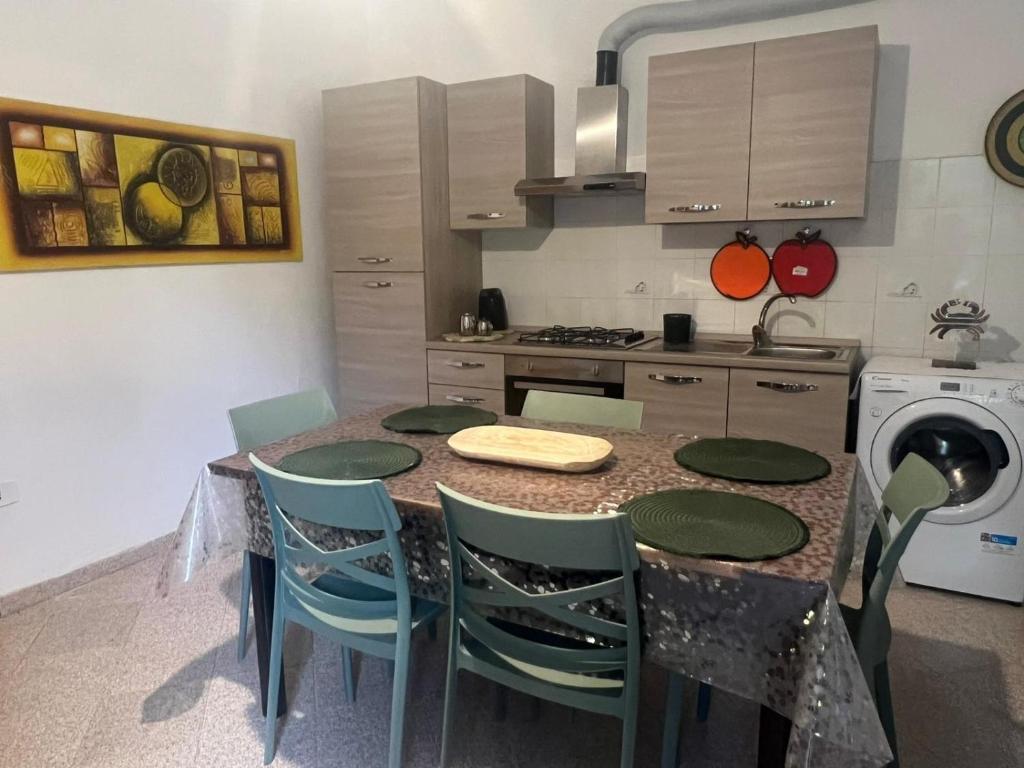 eine Küche mit Tisch und Stühlen und einem Herd in der Unterkunft Appartamento fronte spiaggia in Bari Sardo