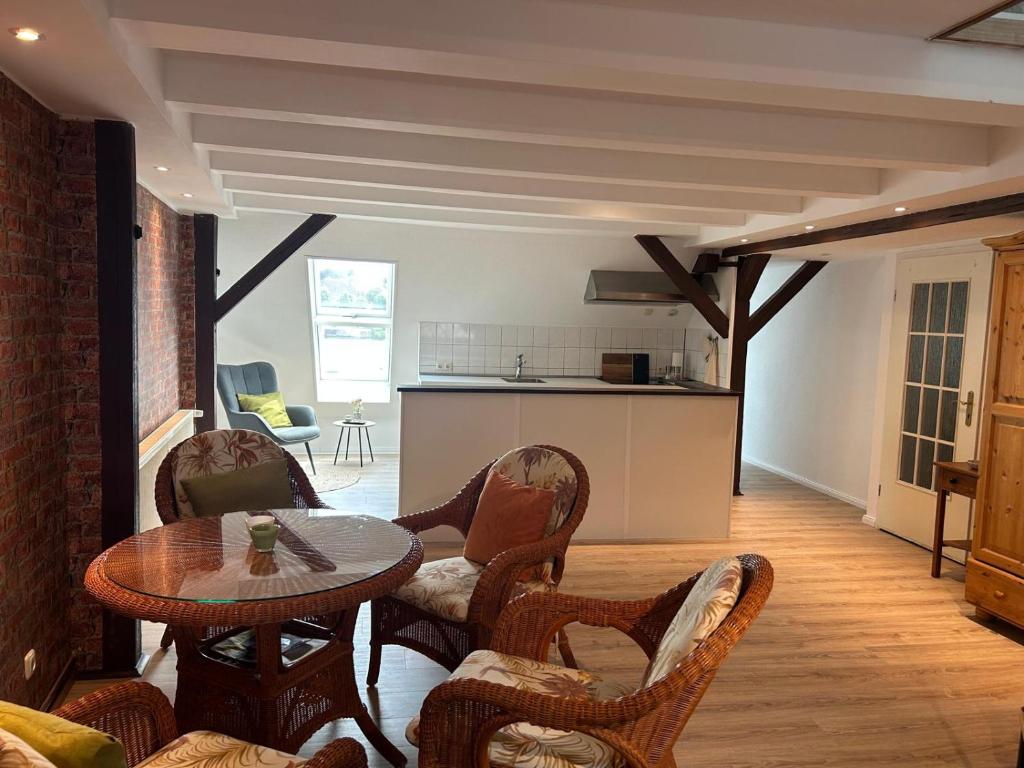 a living room with a table and chairs and a kitchen at Ferienwohnung Klosterblick Insel Malchow mit eigenen Bootsanleger in Malchow