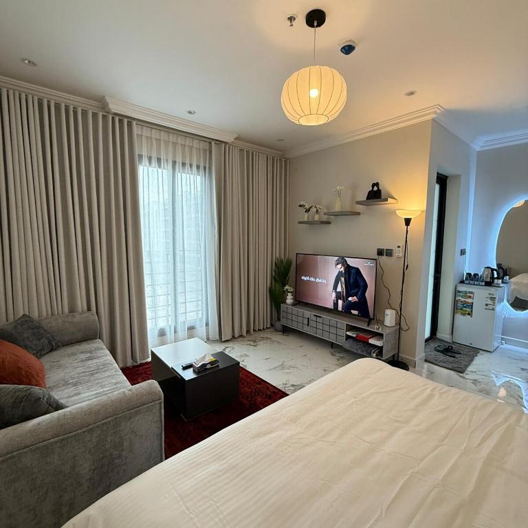 a living room with a bed and a television at Modern Studio, Self-Entry, 2 min to Sea in Dammam