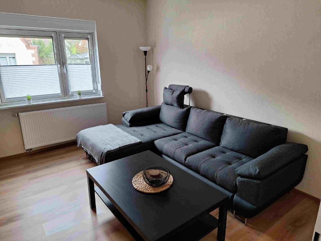 a living room with a blue couch and a table at Ferienwohnung Missionshausstrasse in Sankt Wendel