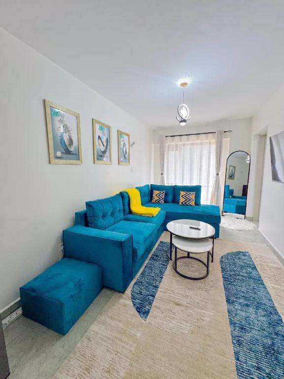 a living room with a blue couch and a table at Destiny homes in Rungiri