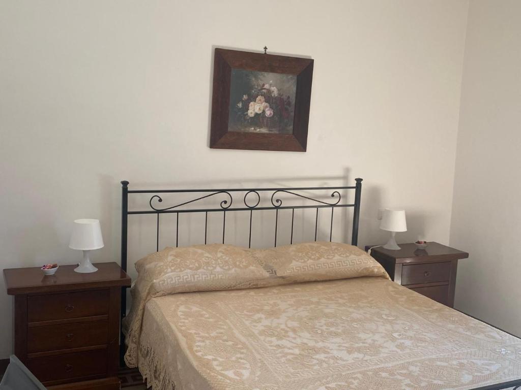 ein Schlafzimmer mit einem Bett mit zwei Nachttischen und zwei Lampen in der Unterkunft La Piazzetta in Cantalupo nel Sannio