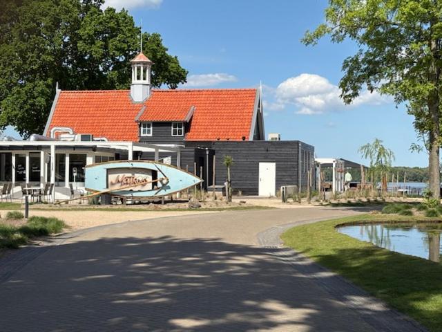 un edificio con una barca sul lato di una strada di Nieuw! Sfeervol Tiny House in de natuur en aan het water a Hulshorst