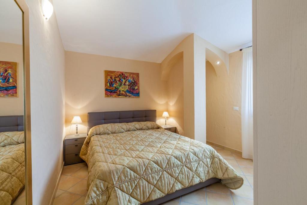 a bedroom with a bed and two night stands with lamps at Appartamento Mare Sardegna Porto San Paolo in Porto San Paolo