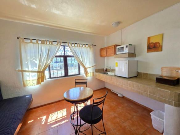 a kitchen with a table and chairs in a room at Hotel Sauces Celaya in Celaya