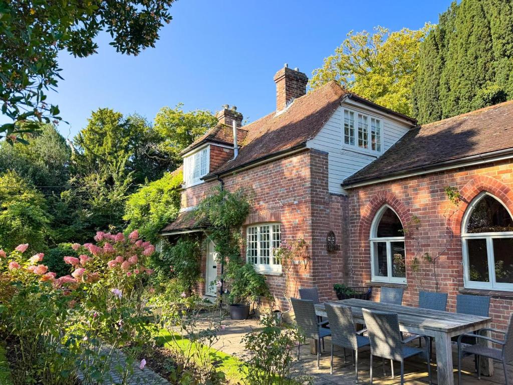 een bakstenen huis met een picknicktafel ervoor bij Castlemans Coach House in Sedlescombe