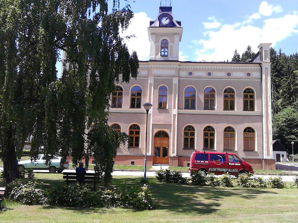 a van parked in front of a large building with a clock tower at Šťastná třináctka in Svoboda nad Úpou