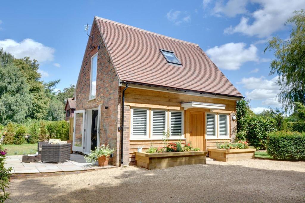 a small brick house with a porch at Beech Cottage at Fir House in Cranbrook