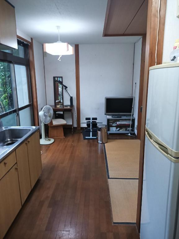 a kitchen with a refrigerator and a tv in it at Minshuku Yamachan - Vacation STAY 19921 in Takamatsu