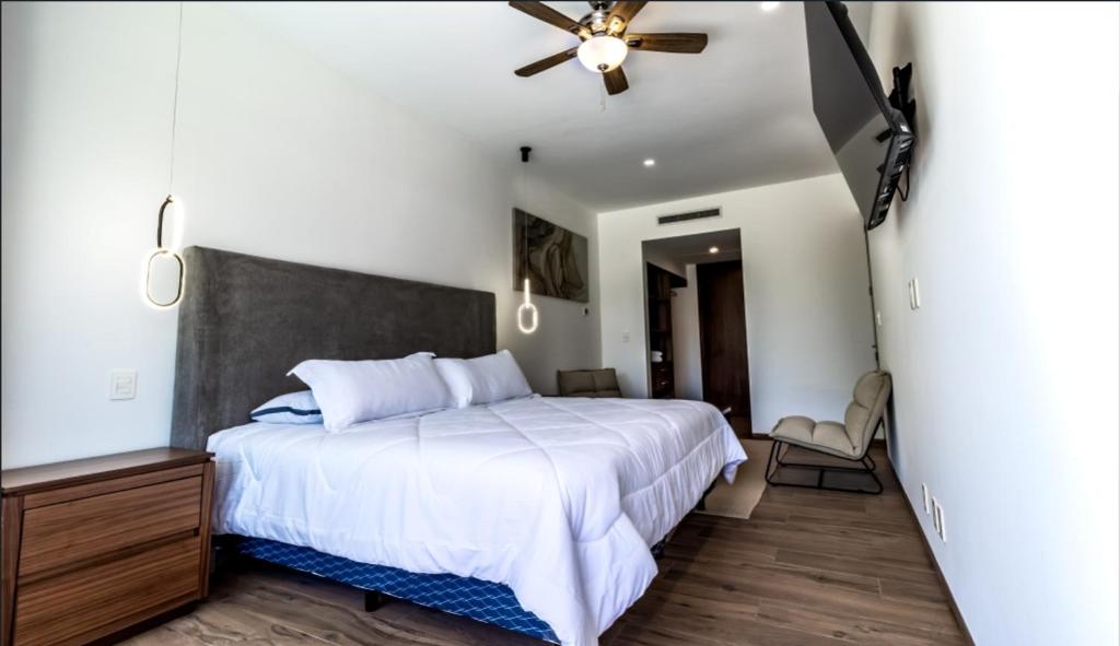 ein Schlafzimmer mit einem Bett und einem Deckenventilator in der Unterkunft Departamento en zona exclusiva a minutos de la playa y de la 5ta Av in Playa del Carmen