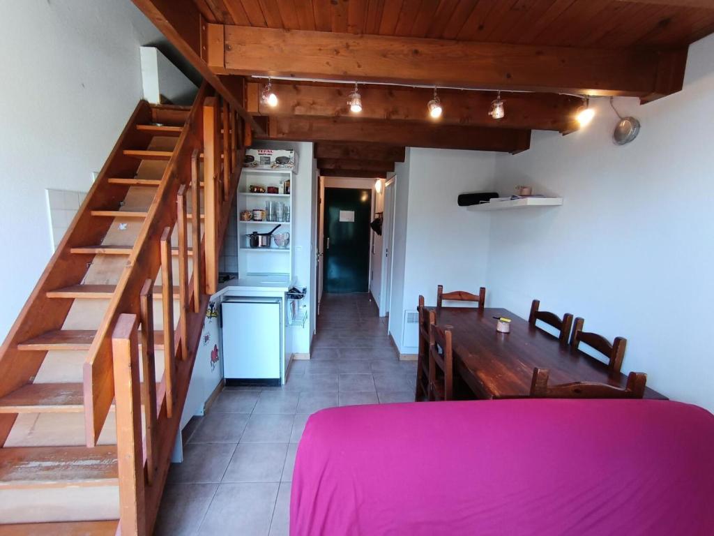ein Raum mit einer Treppe und einem Tisch und einer Küche in der Unterkunft Résidence Plein Soleil - Petit duplex 4 pers plein sud sur les hauteurs du village MAE-2803 in Montgenèvre