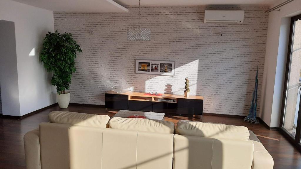a living room with a white couch in front of a brick wall at Dream Apartment in Dąbrowa Górnicza