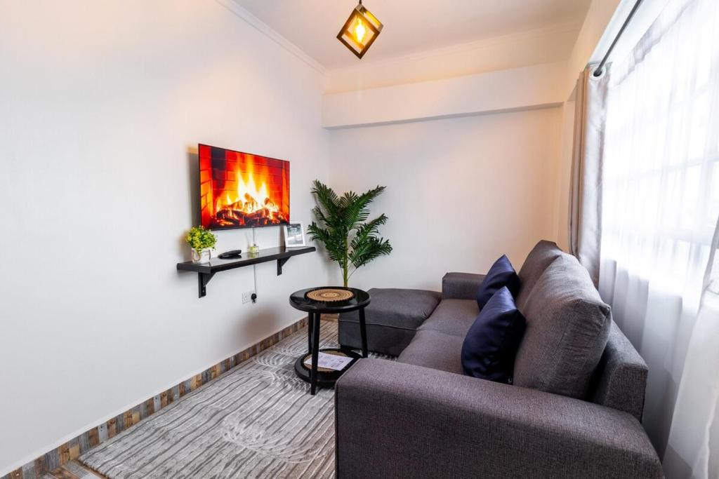 a living room with a couch and a painting on the wall at Taraji's Nest Homestays in Nanyuki