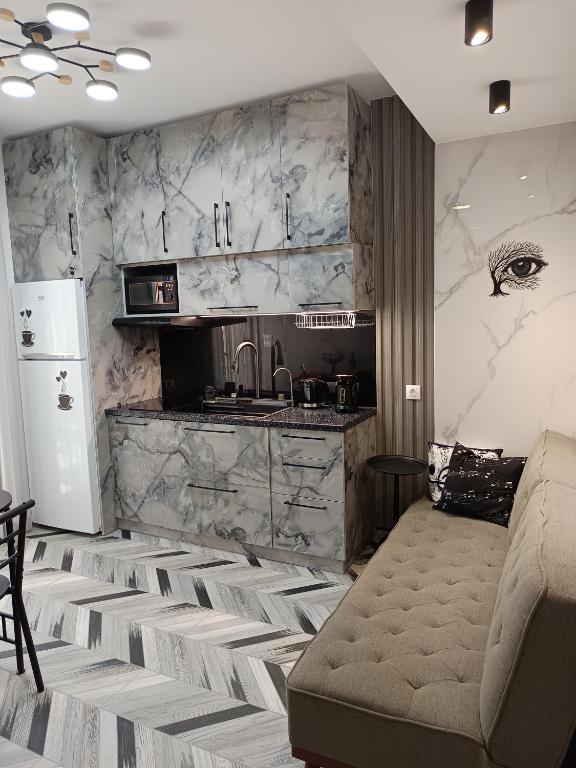 a living room with a couch and a kitchen at Olga Luxury Apartment in Paralia Katerinis