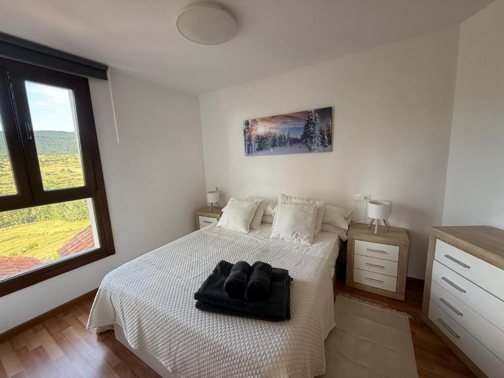 a bedroom with a white bed with a black bag on it at el mirador de ona in Valdelinares