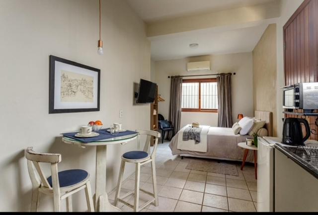 a kitchen and living room with a couch and a table at Estúdio térreo nas margens da Lagoa in Florianópolis