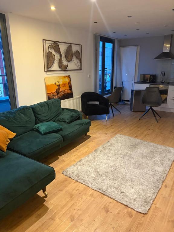 ein Wohnzimmer mit einer grünen Couch und einem Teppich in der Unterkunft Rooftop 2 Bed Penthouse, Hot Tub, Wrapped Balcony, Free Parking, Train Station Location by Opulent Stays in Derby