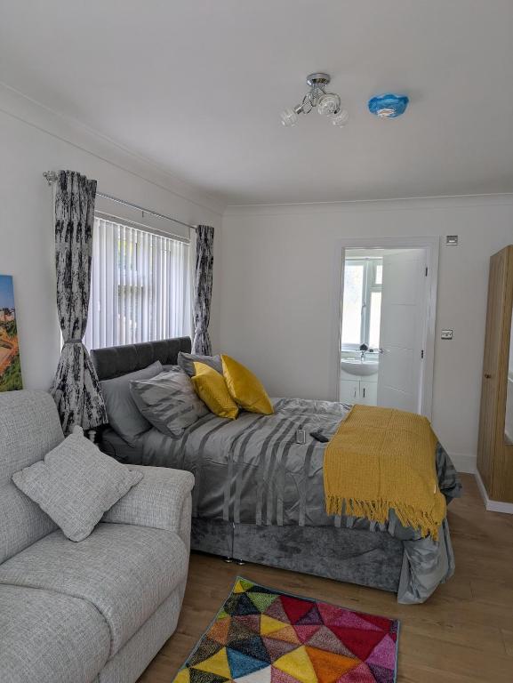 a bedroom with a bed and a couch at Pinecroft in Pembrokeshire