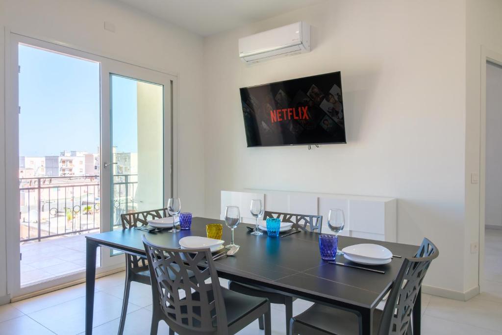 a dining room with a black table and chairs at Casa Bea & Gin - Via Giacomo Matteotti 2A in Sassari