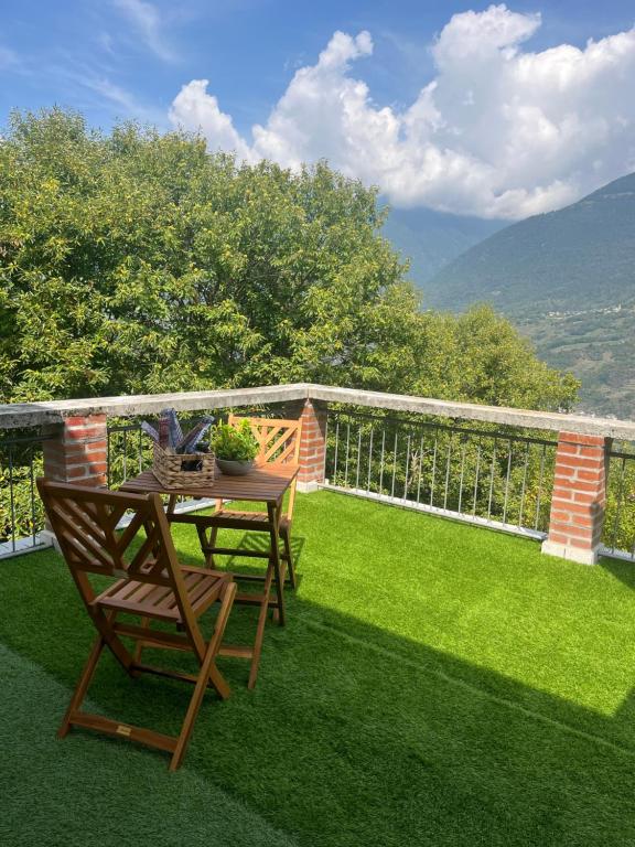 een patio met een tafel en stoelen op het gras bij La Terrazza Panoramica in San Sebastiano