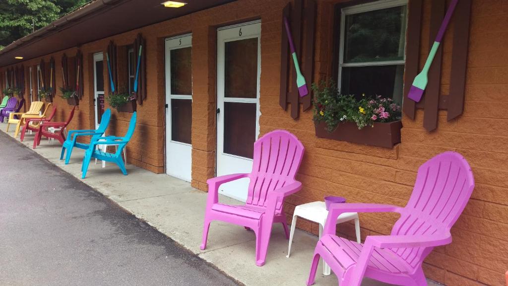 un groupe de chaises assis à l'extérieur d'un bâtiment dans l'établissement Alpine Motel, à Branch Township