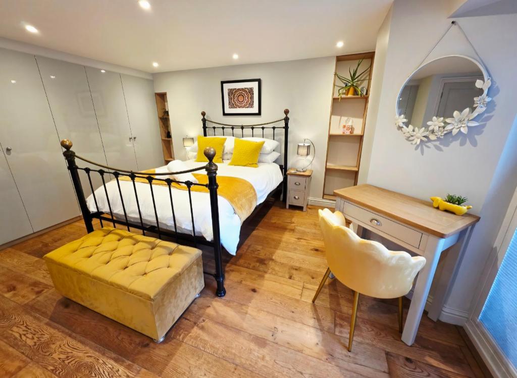 Un dormitorio con una cama con almohadas amarillas y una silla en North Devon Luxe Gem for 4, 2 Ensuite Beds, Elegantly Renovated Sea Nearby, en Ilfracombe
