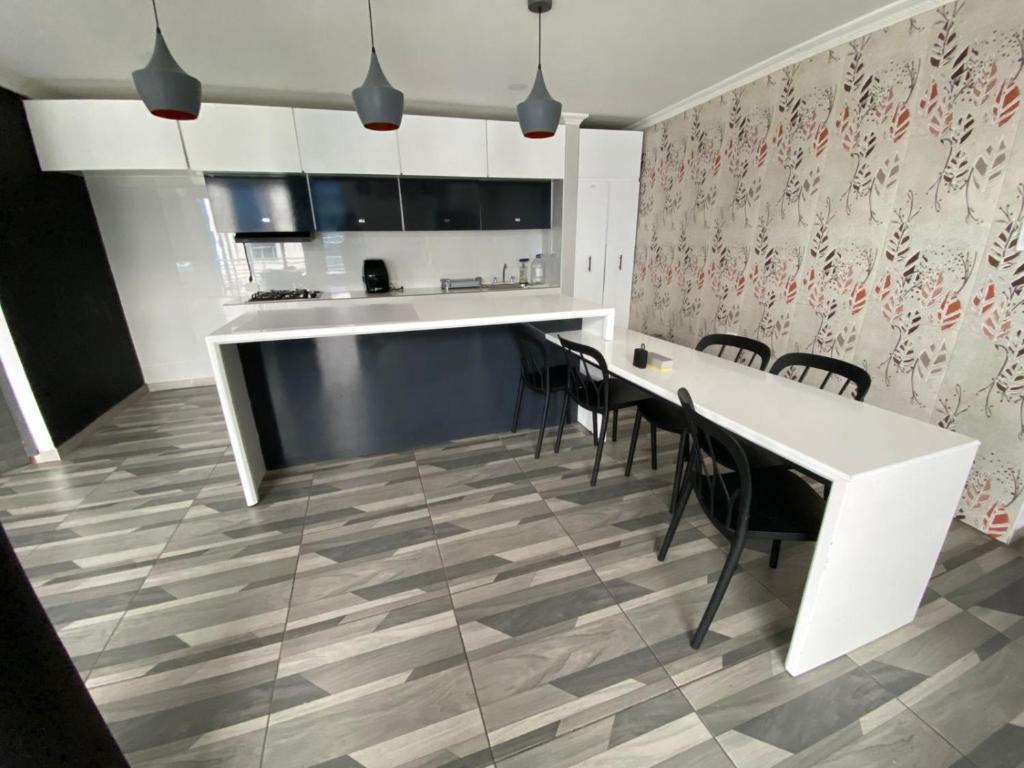 a kitchen with a white table and chairs at Hotel residencial bella vista in Mocoa