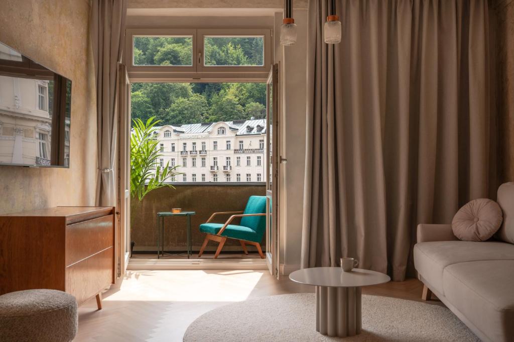 Una sala de estar con un sofá y una ventana. en Limewash Apartments Karlsbad, en Karlovy Vary