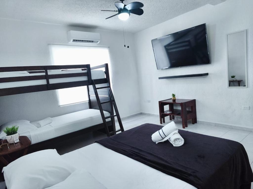 ein Schlafzimmer mit einem Etagenbett und einem Flachbild-TV in der Unterkunft sunrise in Cancun in Cancún