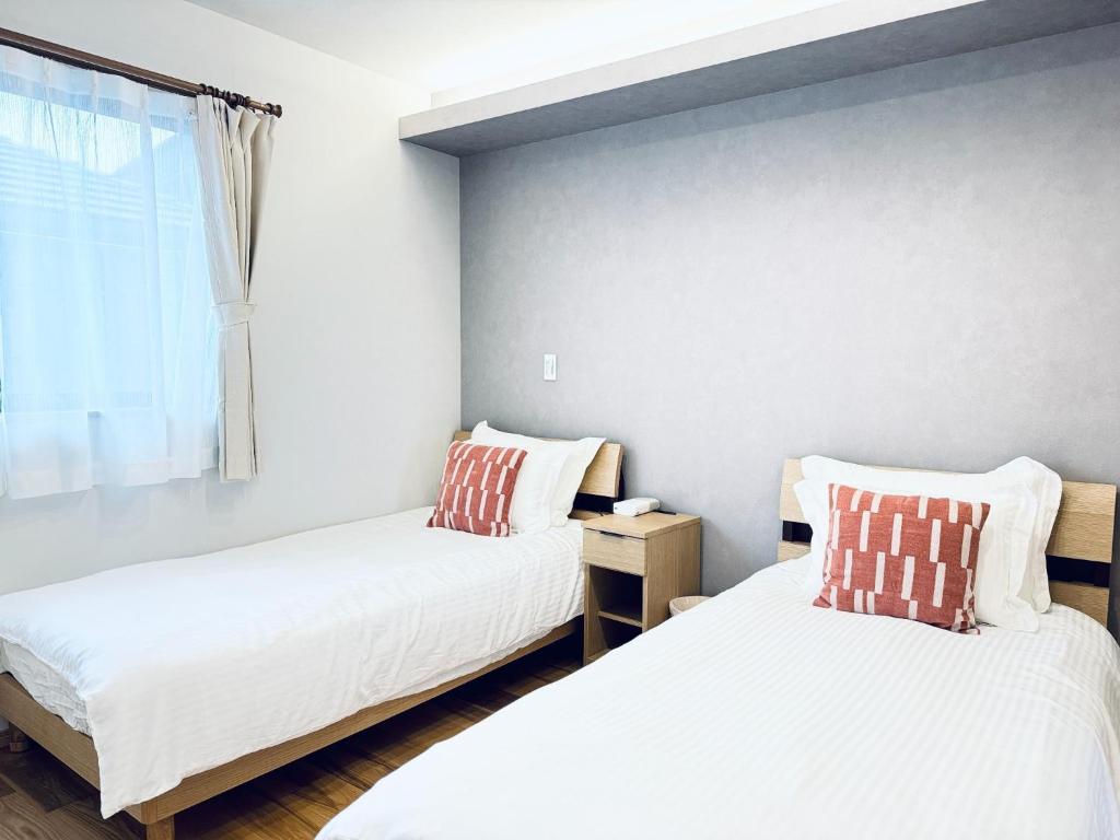 a bedroom with two beds and a window at Akikawa Villas 13 - Vacation STAY 18846 in Fukumoto