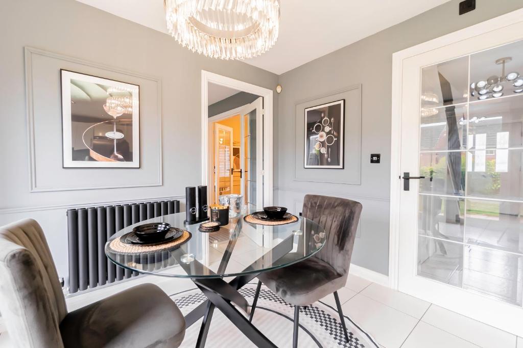 ein Esszimmer mit Glastisch und Stühlen in der Unterkunft Three Bedroom Birmingham Stay Free Parking Perfect for Families Travellers Professionals M6 in Birmingham