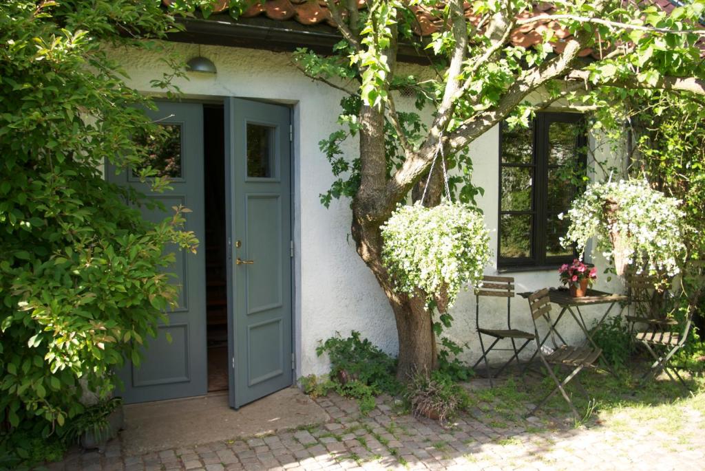 una casa con una puerta azul y un árbol en Trolleberg Bed & Breakfast en Veberöd